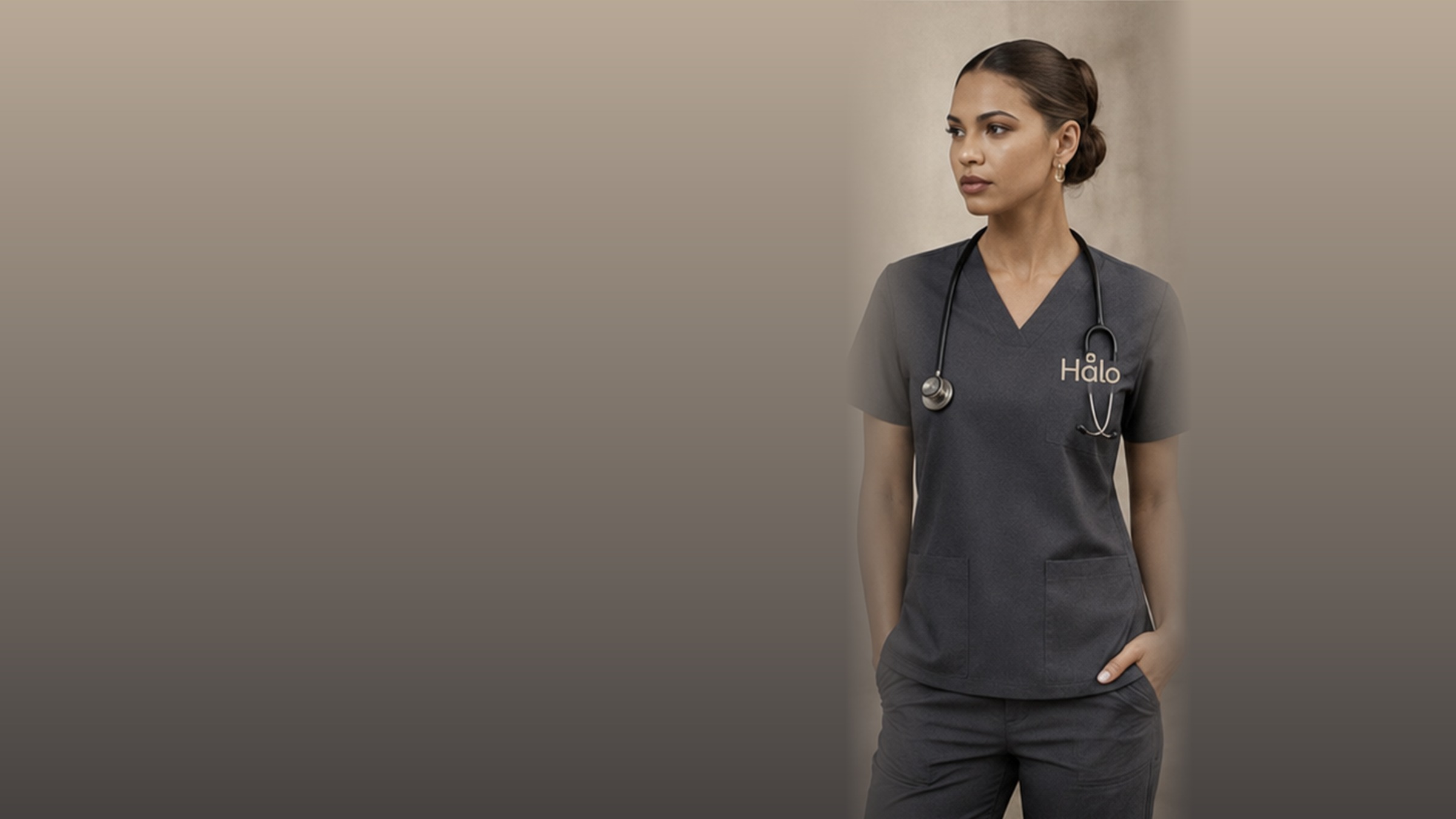 HALO model wearing a charcoal V-neck scrub set with a stethoscope, the HALO mark embroidered at the chest